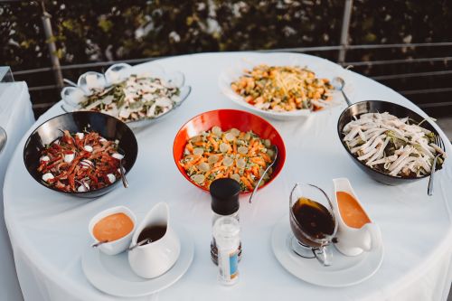 Free An elegant outdoor buffet setup featuring an assortment of salads with various dressings, perfect for events. Stock Photo