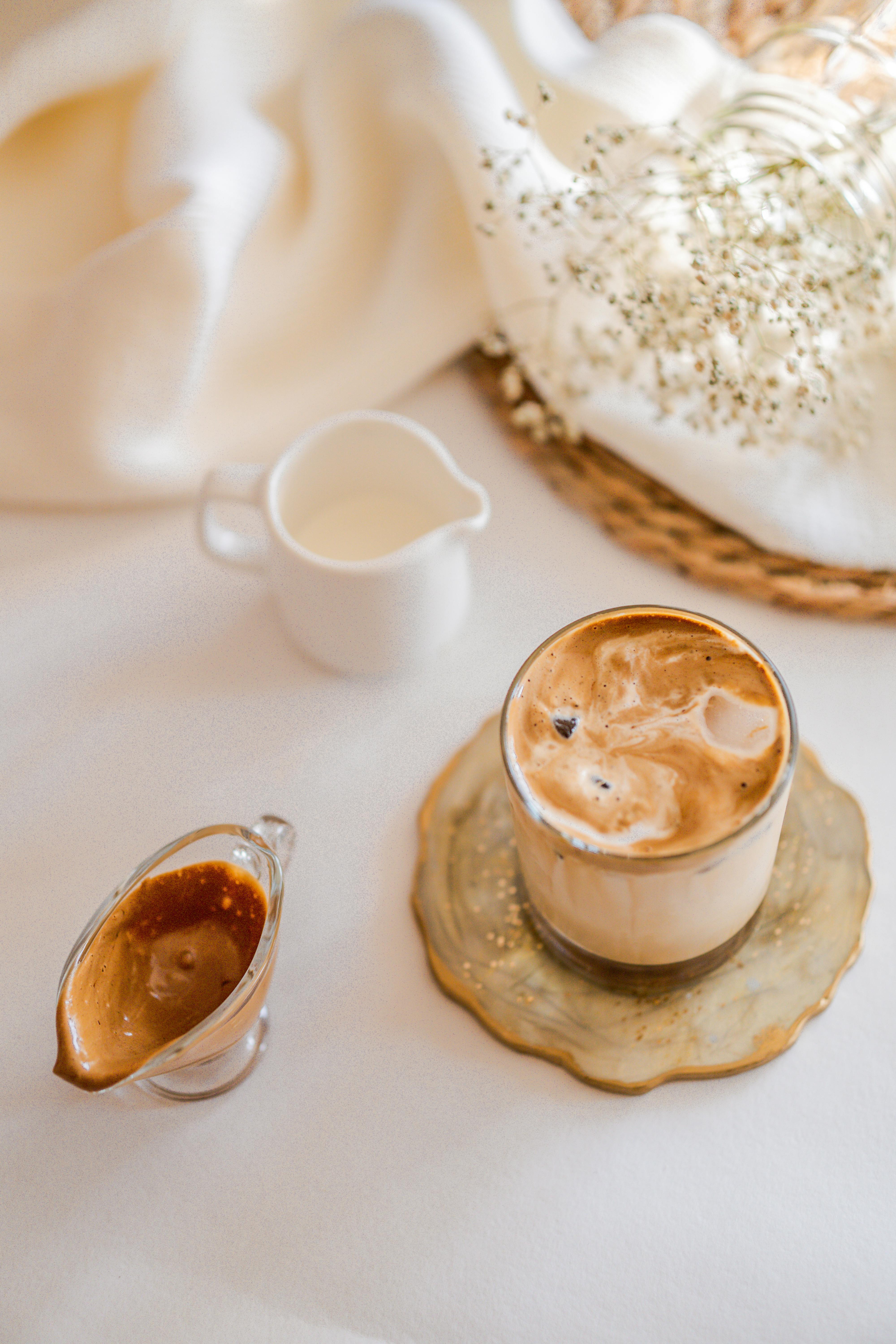 Top-down view of a flat white coffee with cream, on a cozy table setup. Perfect for food and lifestyle themes.