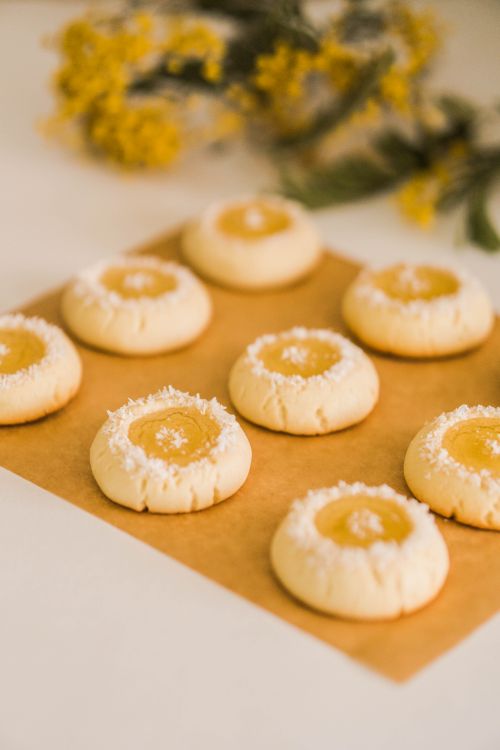 Free Freshly baked lemon thumbprint cookies arranged beautifully on parchment paper, perfect for dessert lovers. Stock Photo