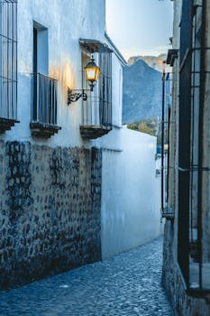 Explore a picturesque Mexican alley with cobblestone streets and rustic architecture, beautifully lit at dusk.
