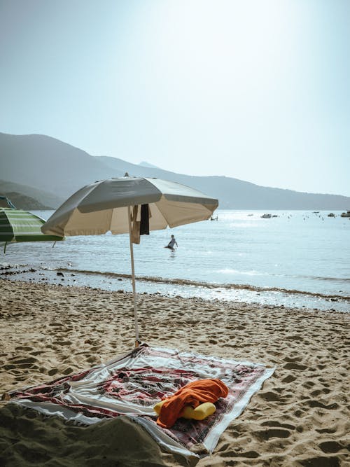 Beach Umbrella and Blanket on Beach