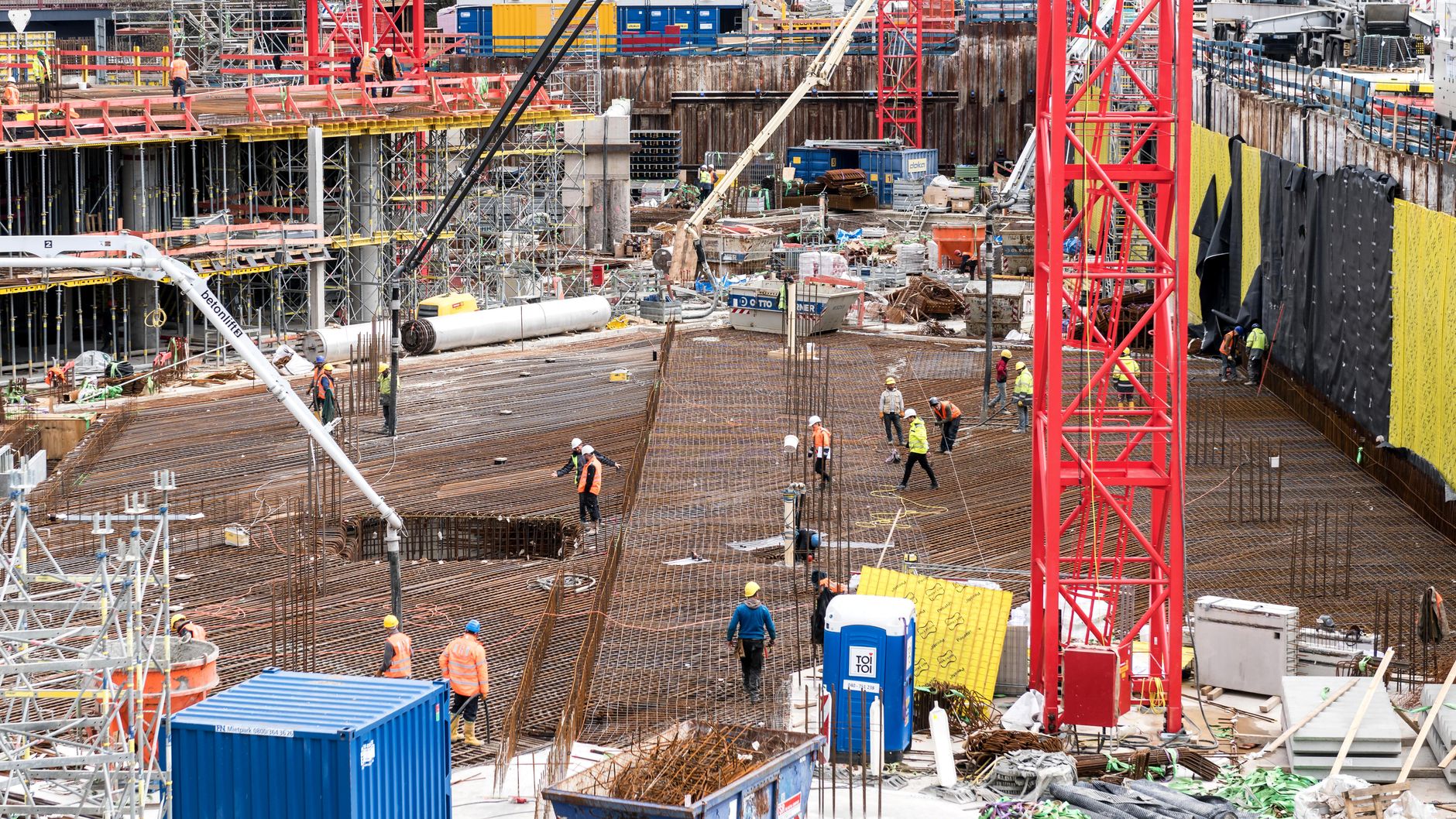 A bustling construction site in Hamburg with workers and equipment actively engaged in building tasks.