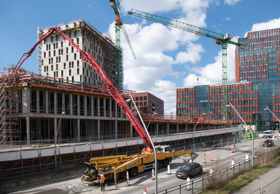 Truck-mounted boom pump placing concrete on an upper floor