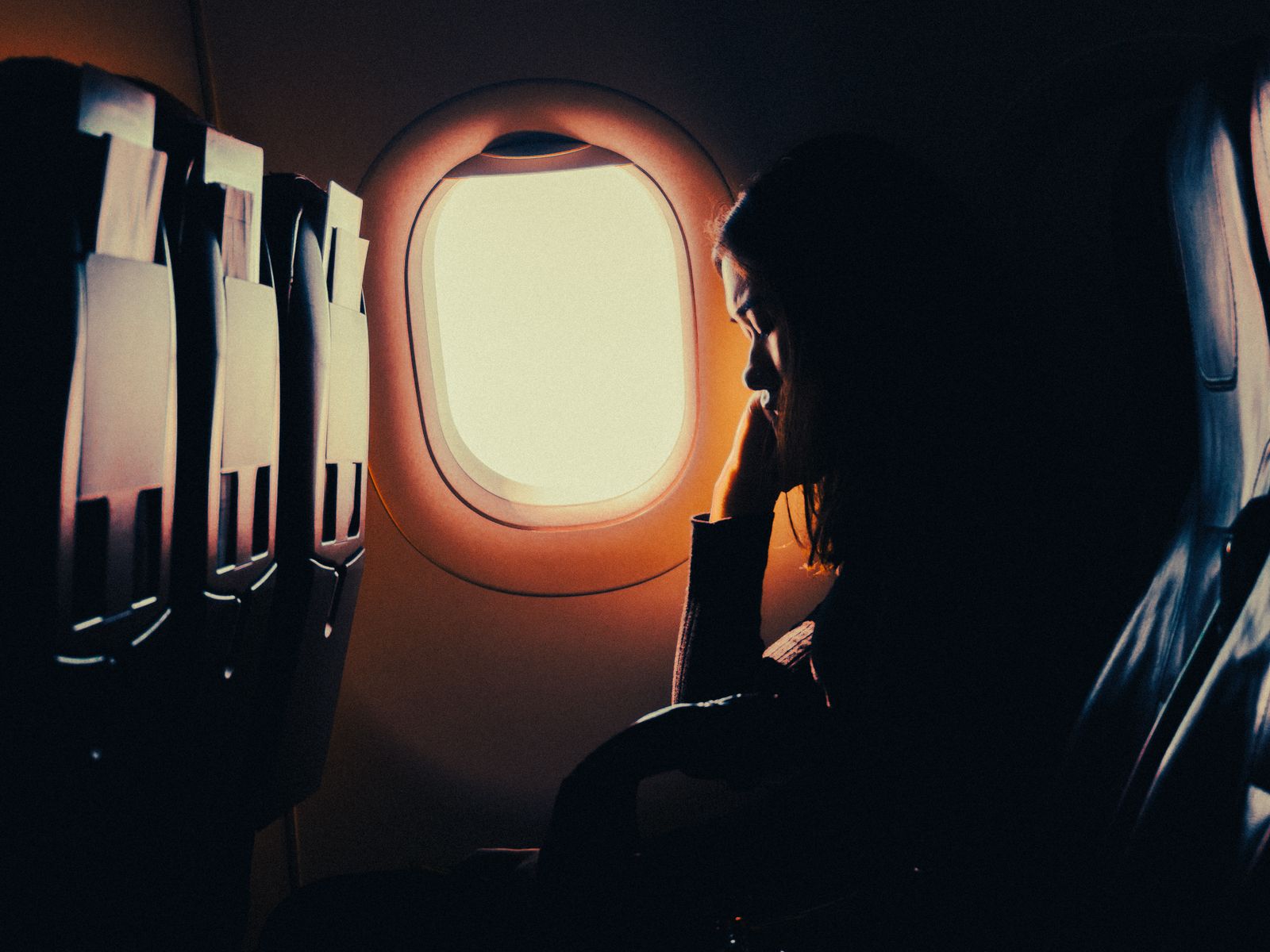 Passenger resting by the window during a long-haul flight