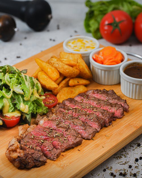 Tray with Sliced Steak Salad Fries and Dips