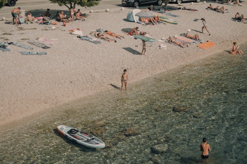 People Relaxing on a Narrow Sea Beach