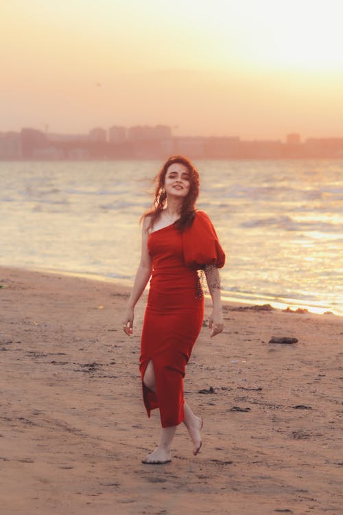 Barefoot Woman in Red Elegant Dress Walking on Beach