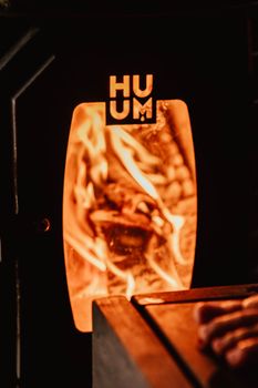 Warm ambiance of a HUUM wood-burning sauna heater with visible flames.