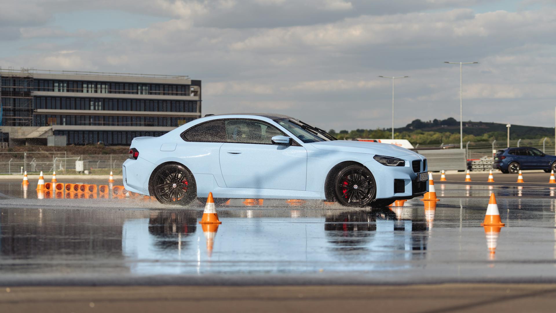 White sports car speeding on a wet circuit, showcasing dynamic motion and racing prowess.