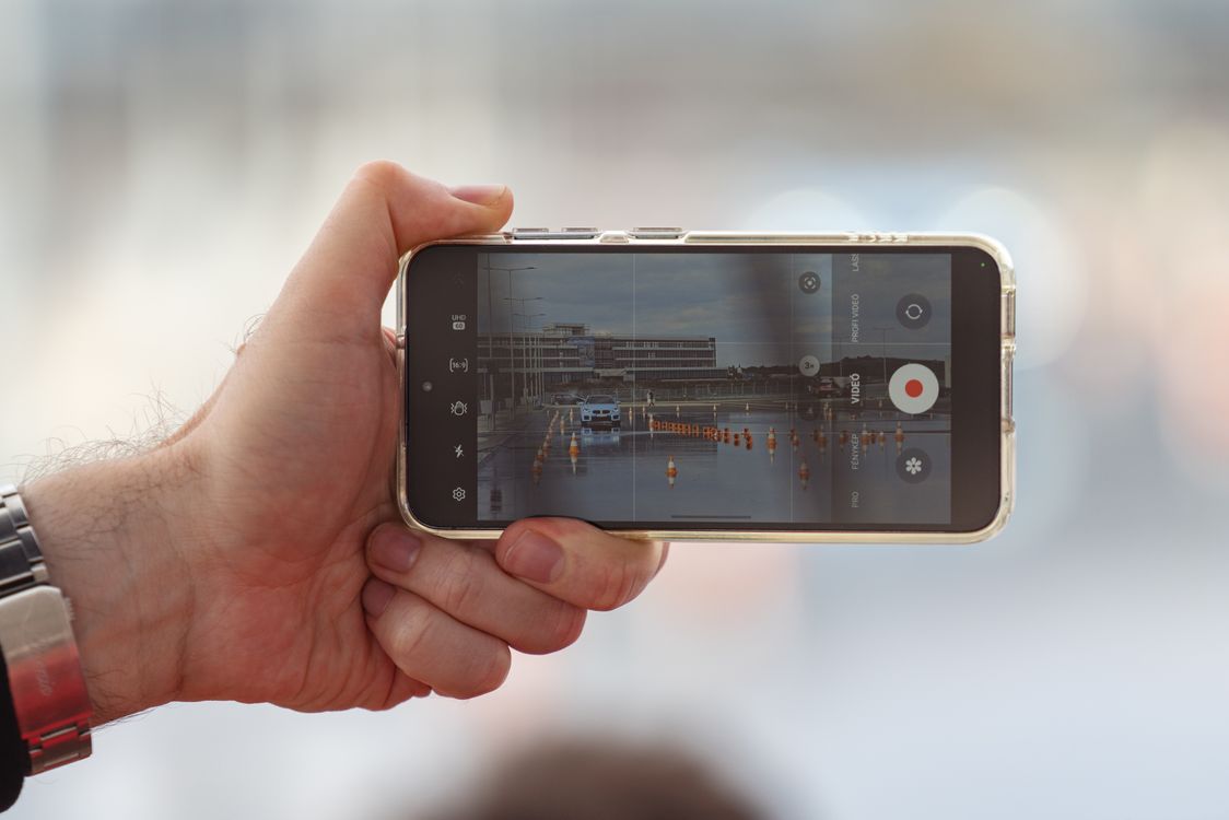 person filming video content with smartphone on tripod