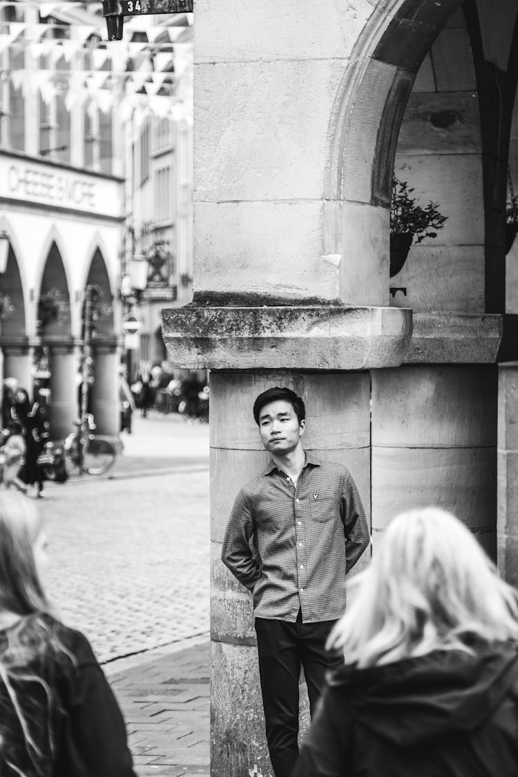 Young Man Posing Near Column On City Square