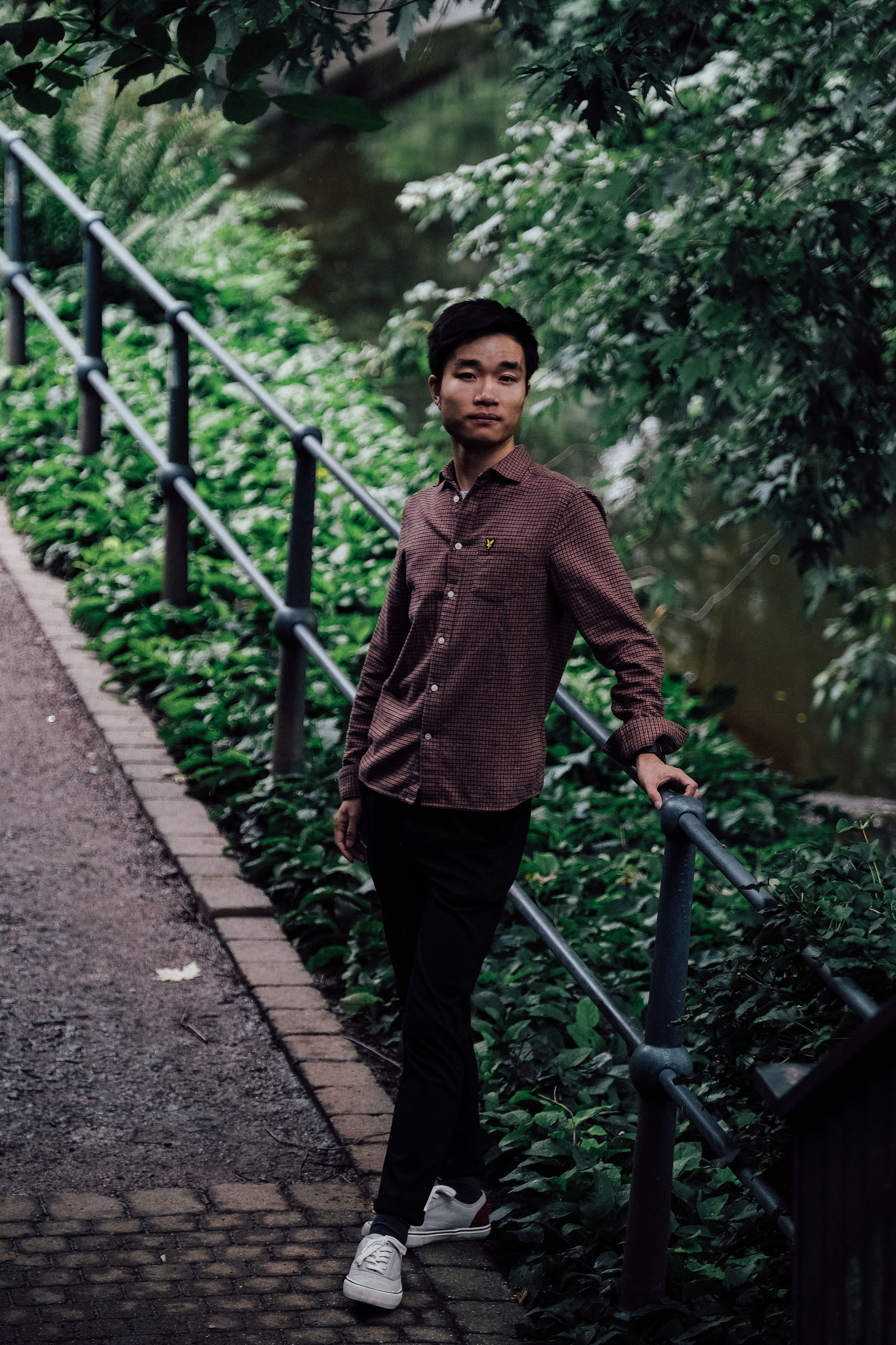 Young Asian Man Standing in a Forest · Free Stock Photo