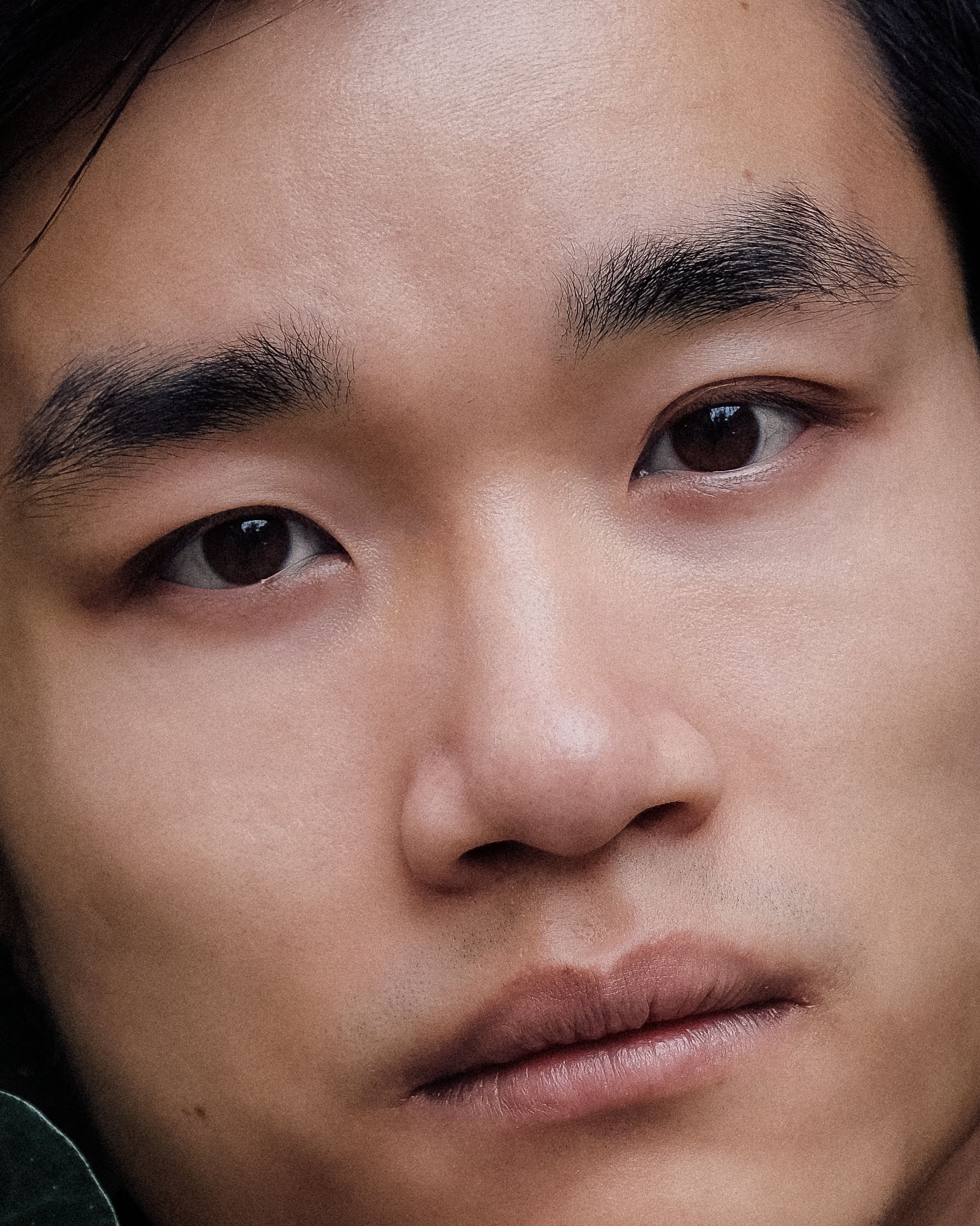 Intimate close-up portrait of a thoughtful young man, showcasing deep expression.