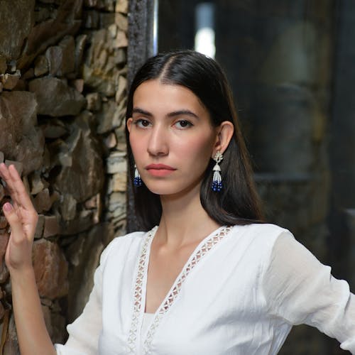 Young Brunette in a White Shirt and Elegant Earrings