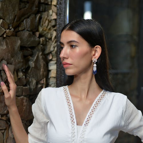 Young Brunette in a White Shirt and Elegant Earrings