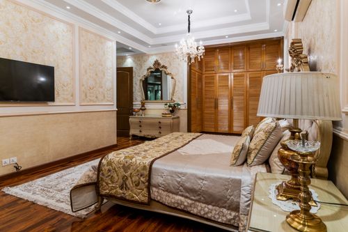 Free Luxurious bedroom featuring elegant decor, classic furnishings, and a chandelier. Stock Photo