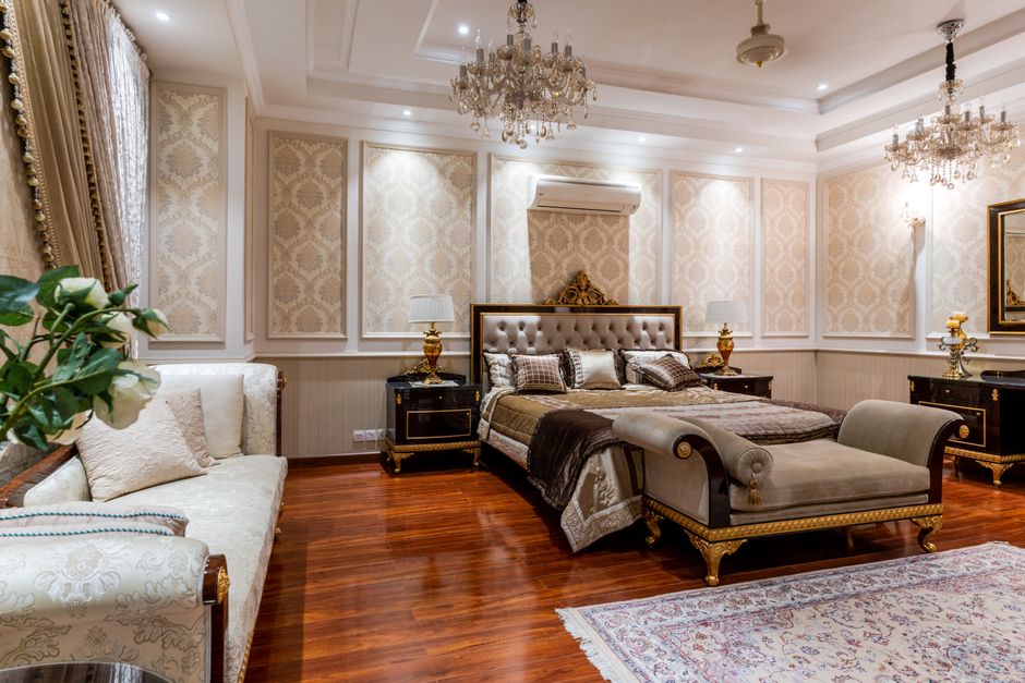 A chic bedroom styling showing a teal velvet duvet cover contrasted with blush pink pillows and light oak wood nightstands