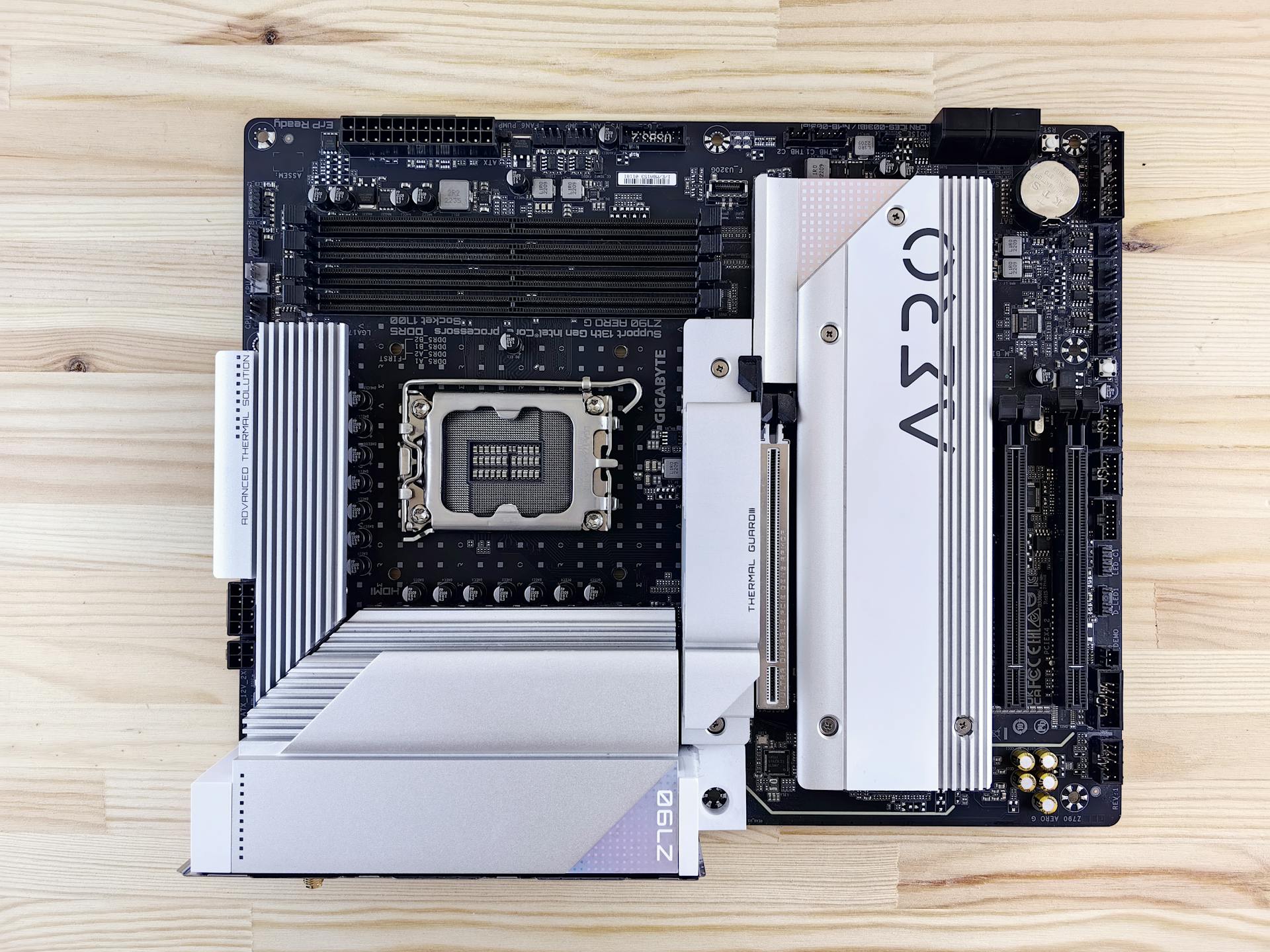 Detailed top view of a modern computer motherboard on a wooden table.