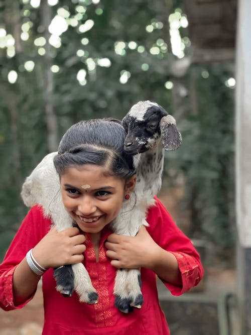 Girl Carrying Lamb on Shoulders