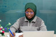 Woman in Green Headscarf Sitting by Laptop
