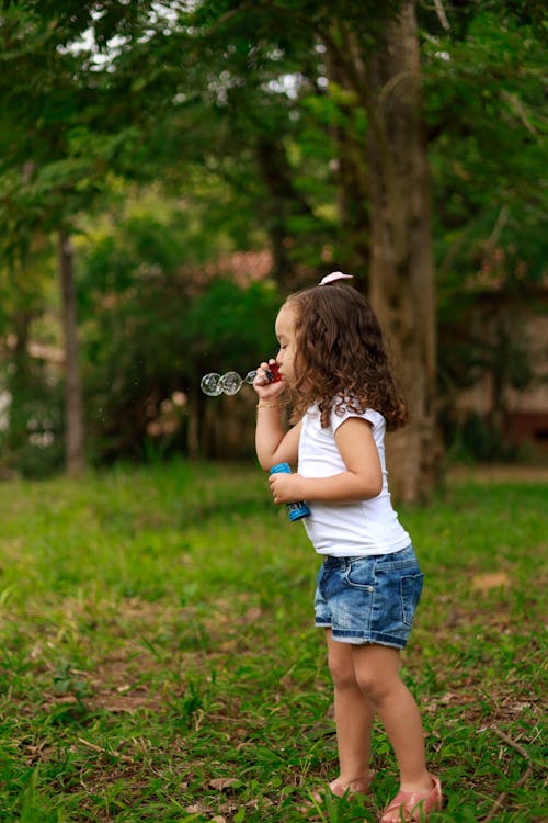 Girl Blowing Bubbles on Meadow