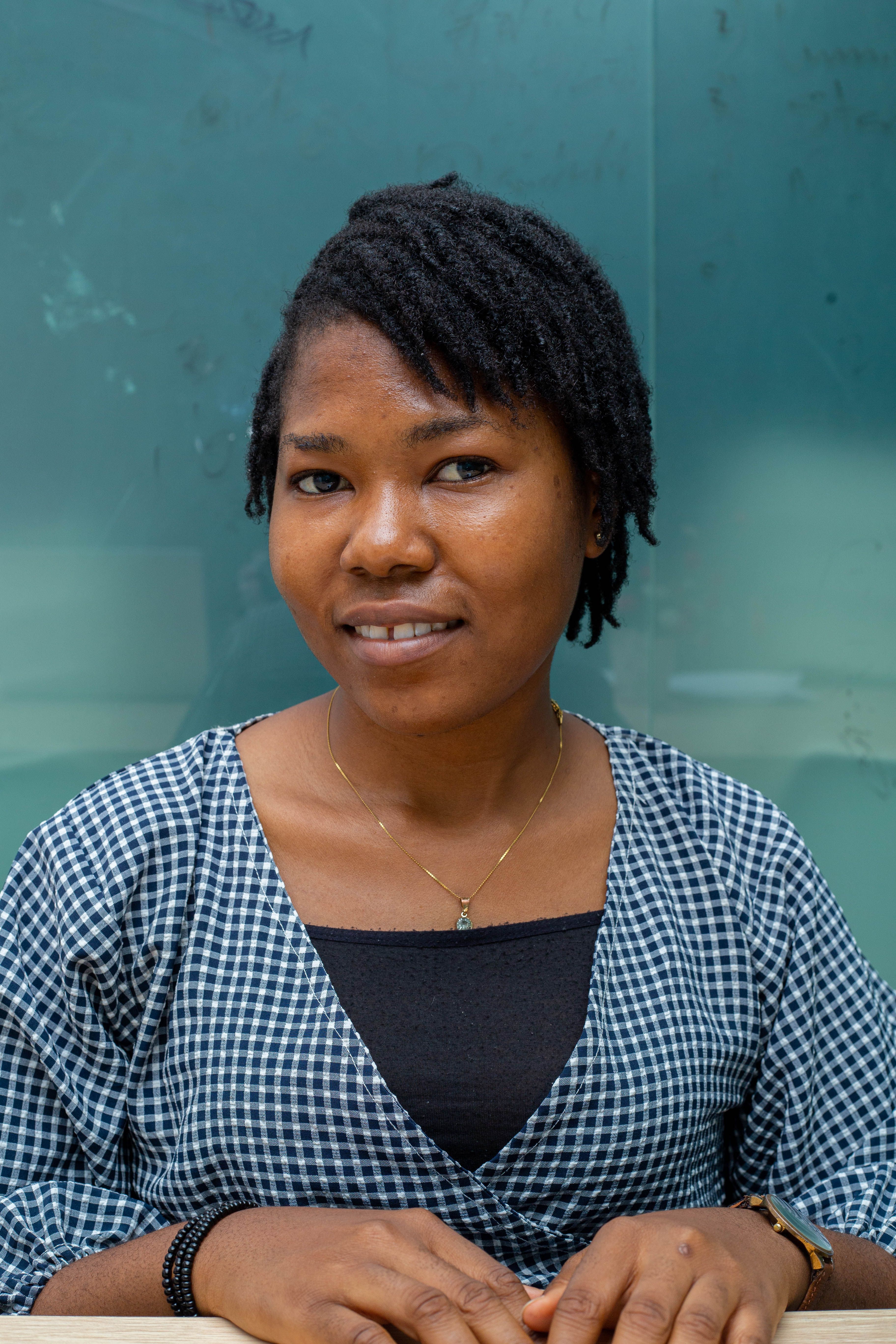 Charming portrait of a smiling woman wearing a checked dress against a modern background.