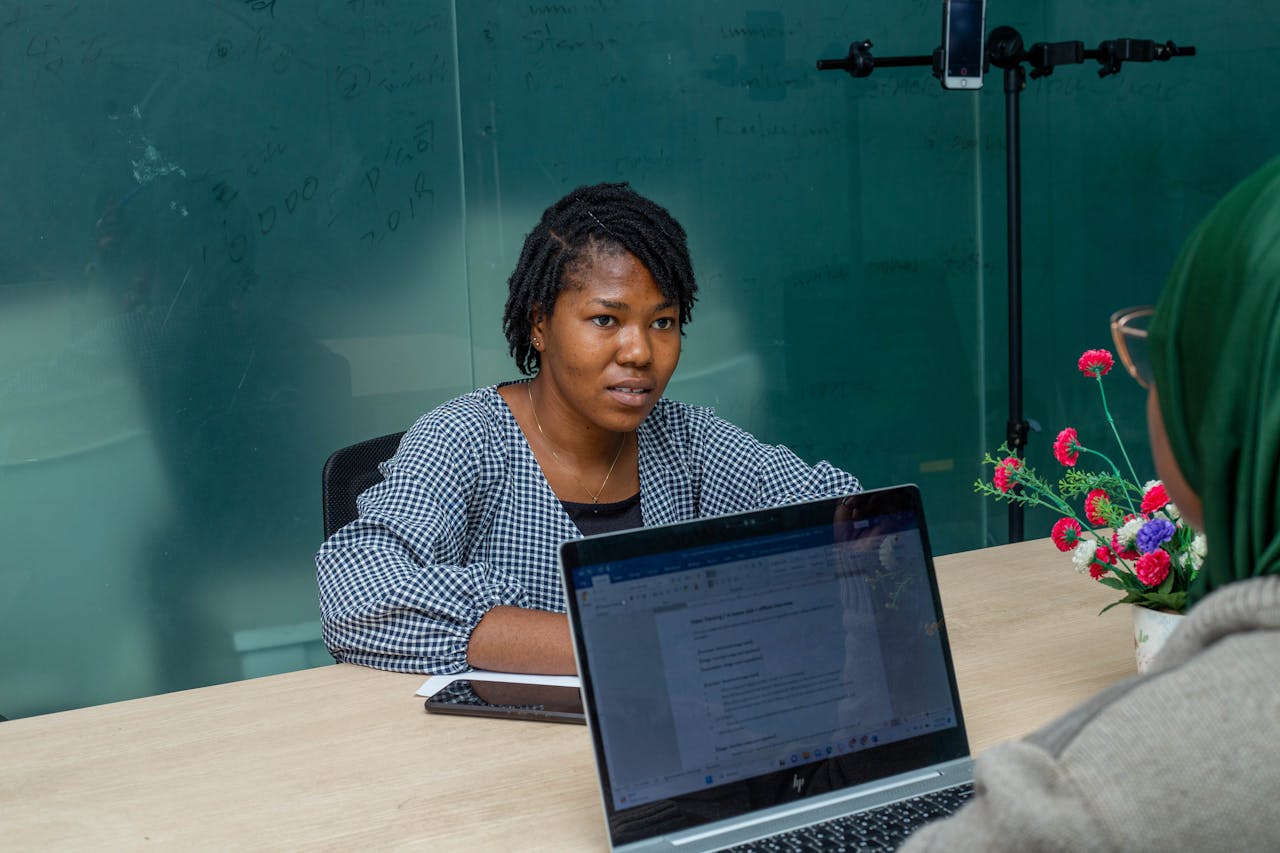 Women professionals in a Lagos office reviewing laptops during a strategy and planning session.