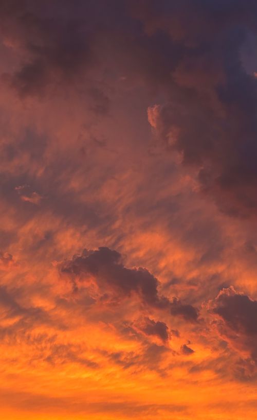 Free A breathtaking sunset sky with vibrant orange and purple clouds creating a dramatic atmosphere. Stock Photo