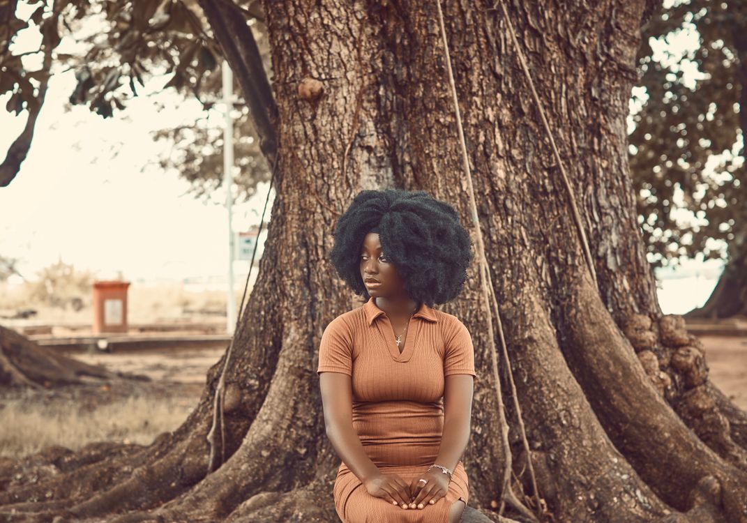 African Woman Sitting in Front of a Tree · Free Stock Photo