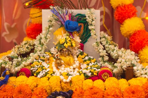 Free Colorful Hindu altar adorned with flowers and a deity figurine, embodying spirituality and tradition. Stock Photo