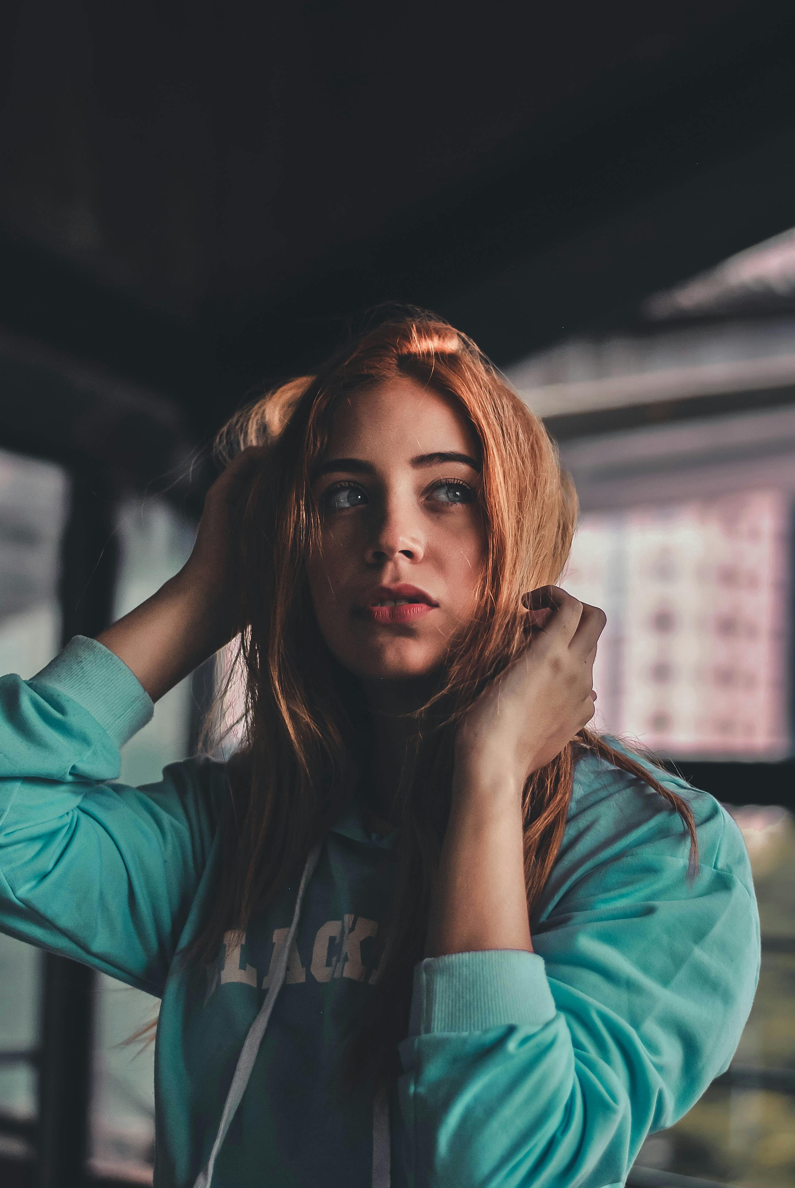 grátis Mulher Vestindo Um Moletom Verde Azulado Perto Do Prédio Ao Ar Livre Foto profissional