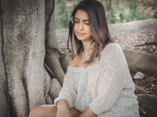 Mulher Com Blusa Branca Sentada Ao Lado Da árvore