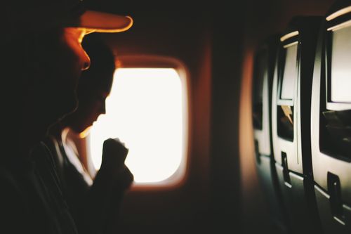 Free Silhouetted passengers sitting by a window during a flight, capturing a serene travel moment. Stock Photo