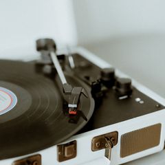 Close-up of the arm on a cream suitcase record player