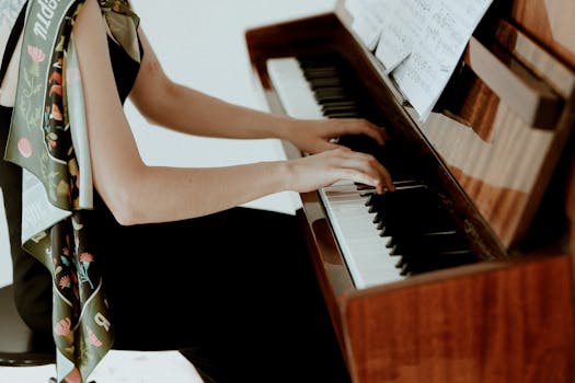 A woman elegantly playing the piano with sheet music in a serene indoor setting.