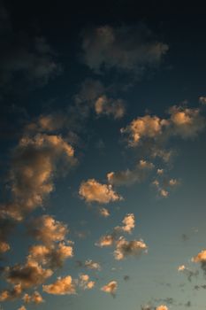 Capture of dramatic sunset with golden clouds against a darkening blue sky.
