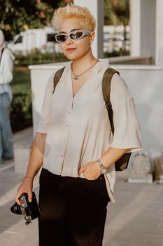 Stylish woman with sunglasses and camera enjoying a sunny day outdoors.