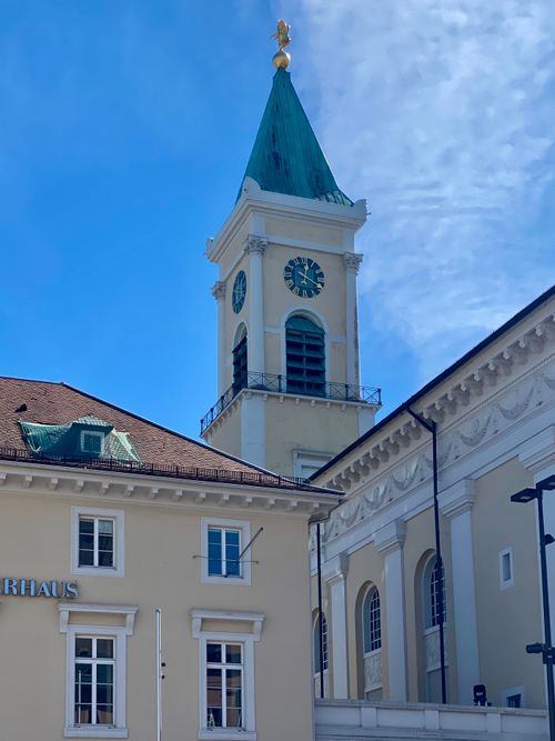 Free Historic church tower stands tall against a bright blue sky in an urban setting. Stock Photo