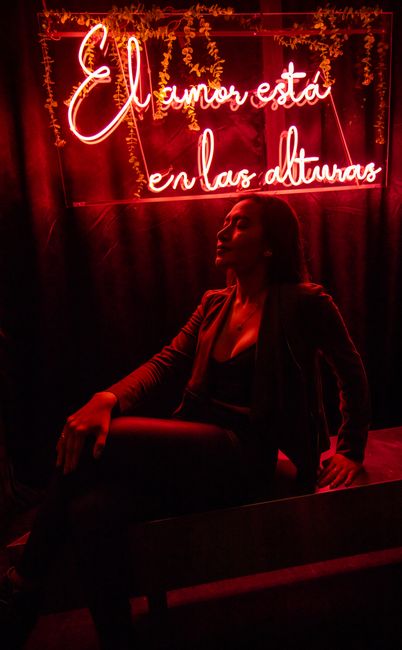A captivating nightlife portrait of a woman in front of a neon sign in Ciudad de México.