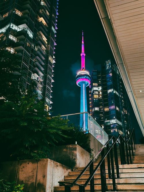 Free Illuminated CN Tower amid Toronto skyscrapers at night, offering a dynamic urban scene. Stock Photo