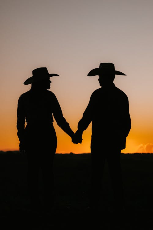 Silhouette of Couple Wearing Cowboy Hats During Sunset 