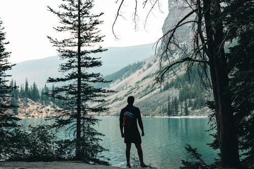 Man Standing on a Shore of Moraine Lake, Banff, Canada
