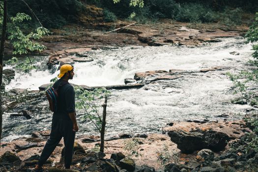 A man with a backpack exploring the scenic river landscape in Port Alberni, BC, Canada.