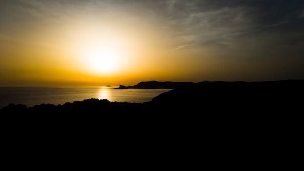 Stunning sunset view over Marseille's rocky coastline with vibrant hues.