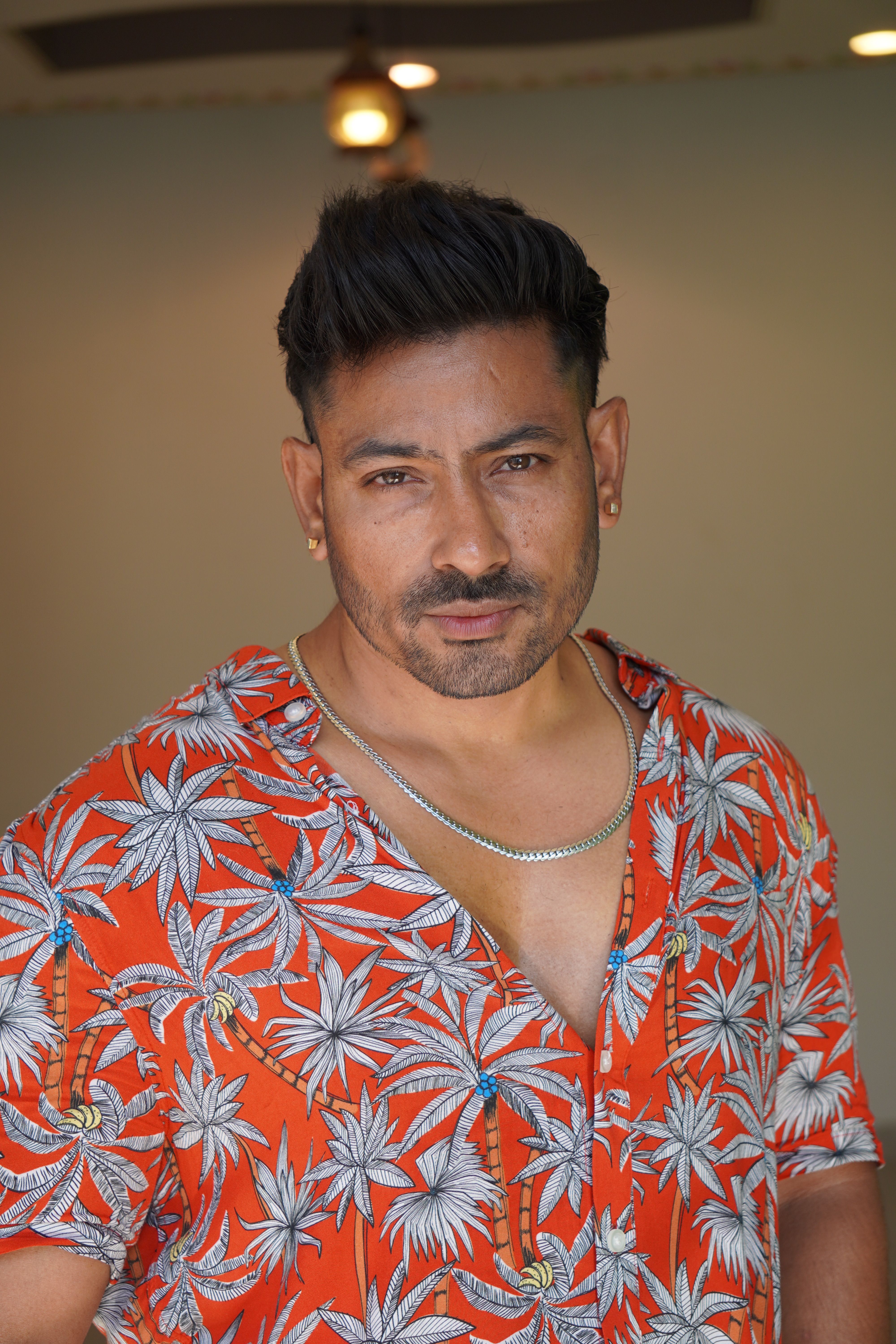 Portrait of a confident man wearing a tropical shirt, exuding style and charisma.