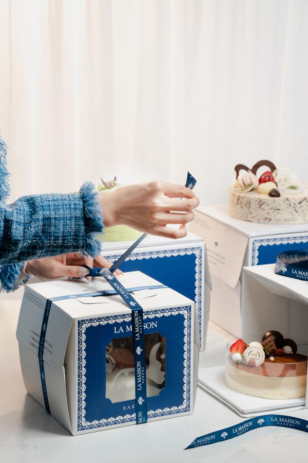 Cake boxes being tied with ribbon