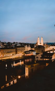 Stunning twilight aerial shot of Zurich's illuminated cityscape featuring historic architecture.