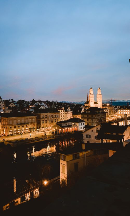 Free Stunning twilight aerial shot of Zurich's illuminated cityscape featuring historic architecture. Stock Photo