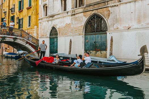 Tourists enjoy a gondola ride on Venice's canals, a glimpse of traditional Italian architecture.