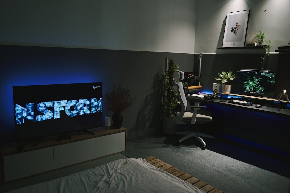 Free Flat TV Near Computer Setup in Bedroom Stock Photo